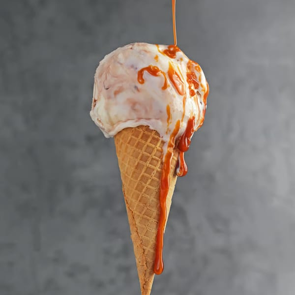 Mayberry Ice Cream's vanilla ice cream cone with caramel sauce drizzling down the sides.