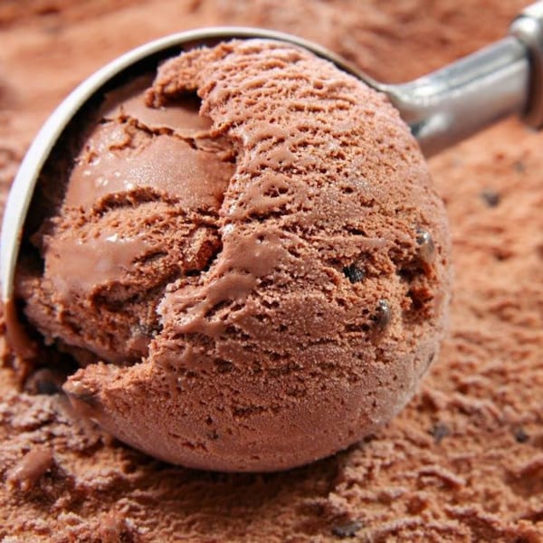 A metal scoop filled with rich chocolate ice cream, ready to be served.